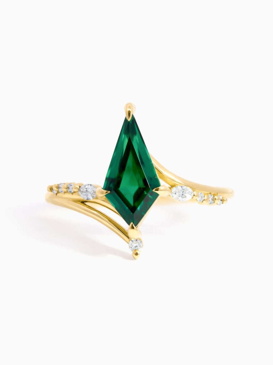 Front View of asymmetrical nouveau gold ring with a emerald kite with pave gallery