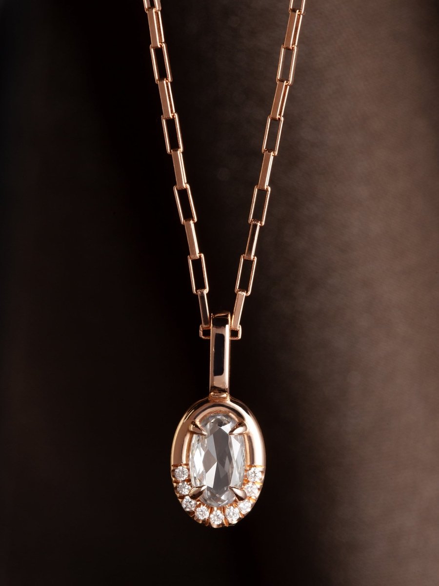 Rose gold necklace with a pendant on a dark background
