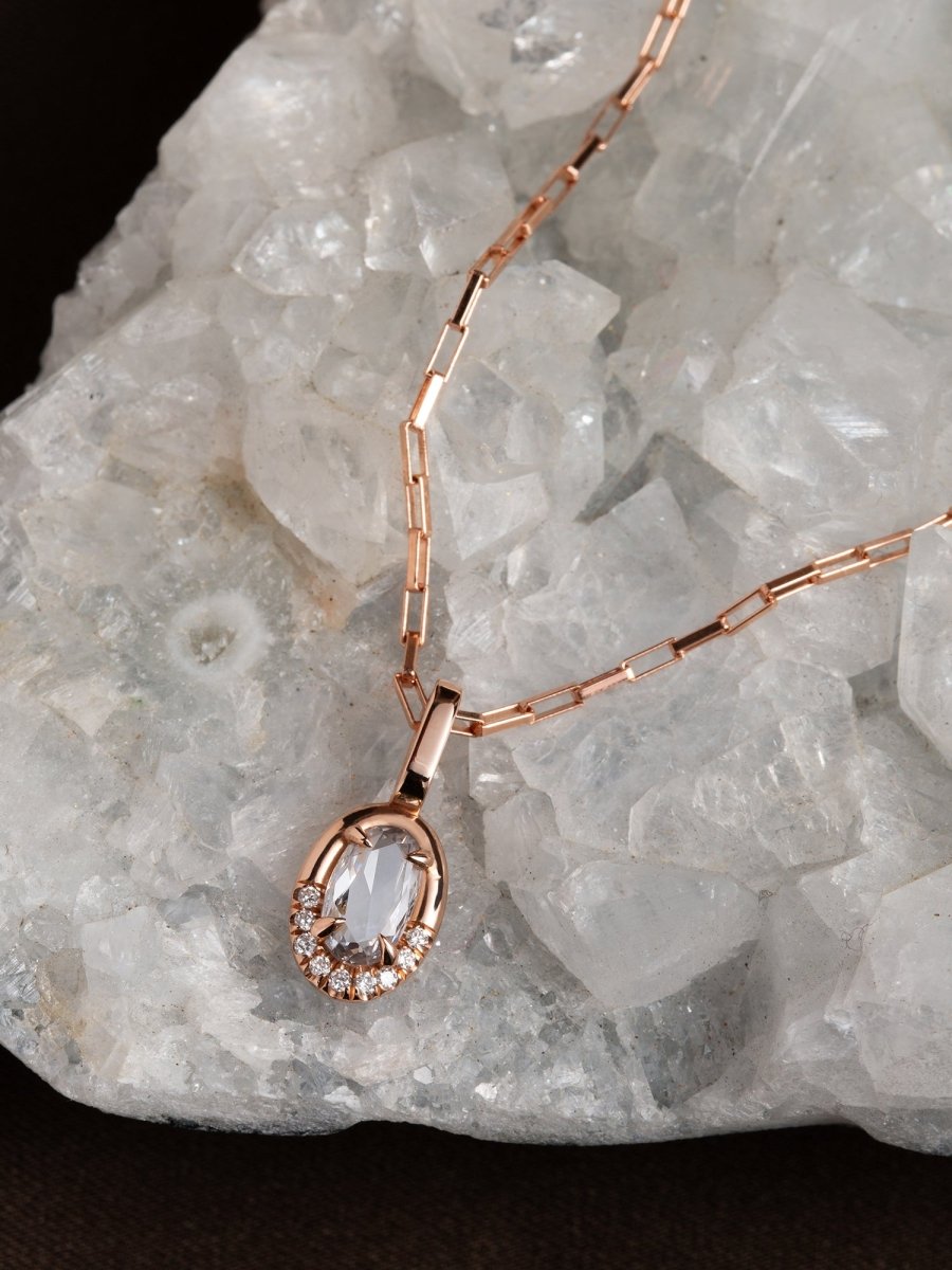 Rose gold necklace with a pendant on a crystal background