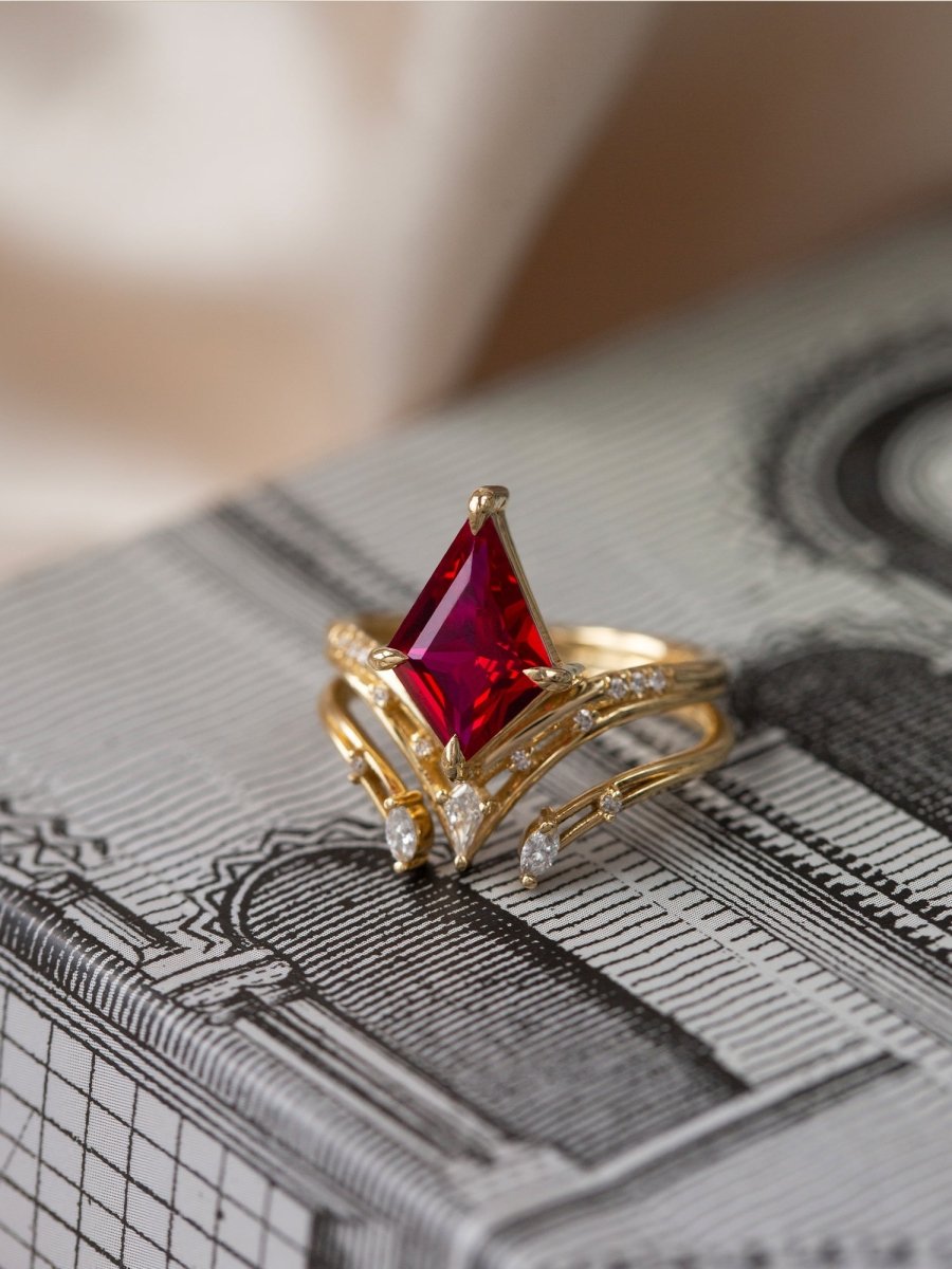 Gold ring with a red gemstone on a textured surface