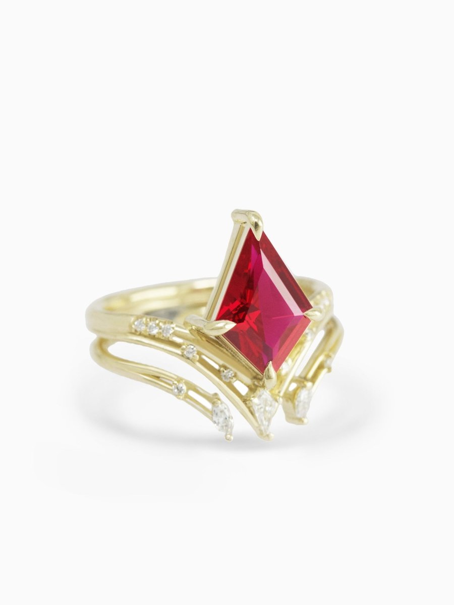 side view of chevron engagement ring with ruby kite center and accents stacked with open marquise diamond wedding band