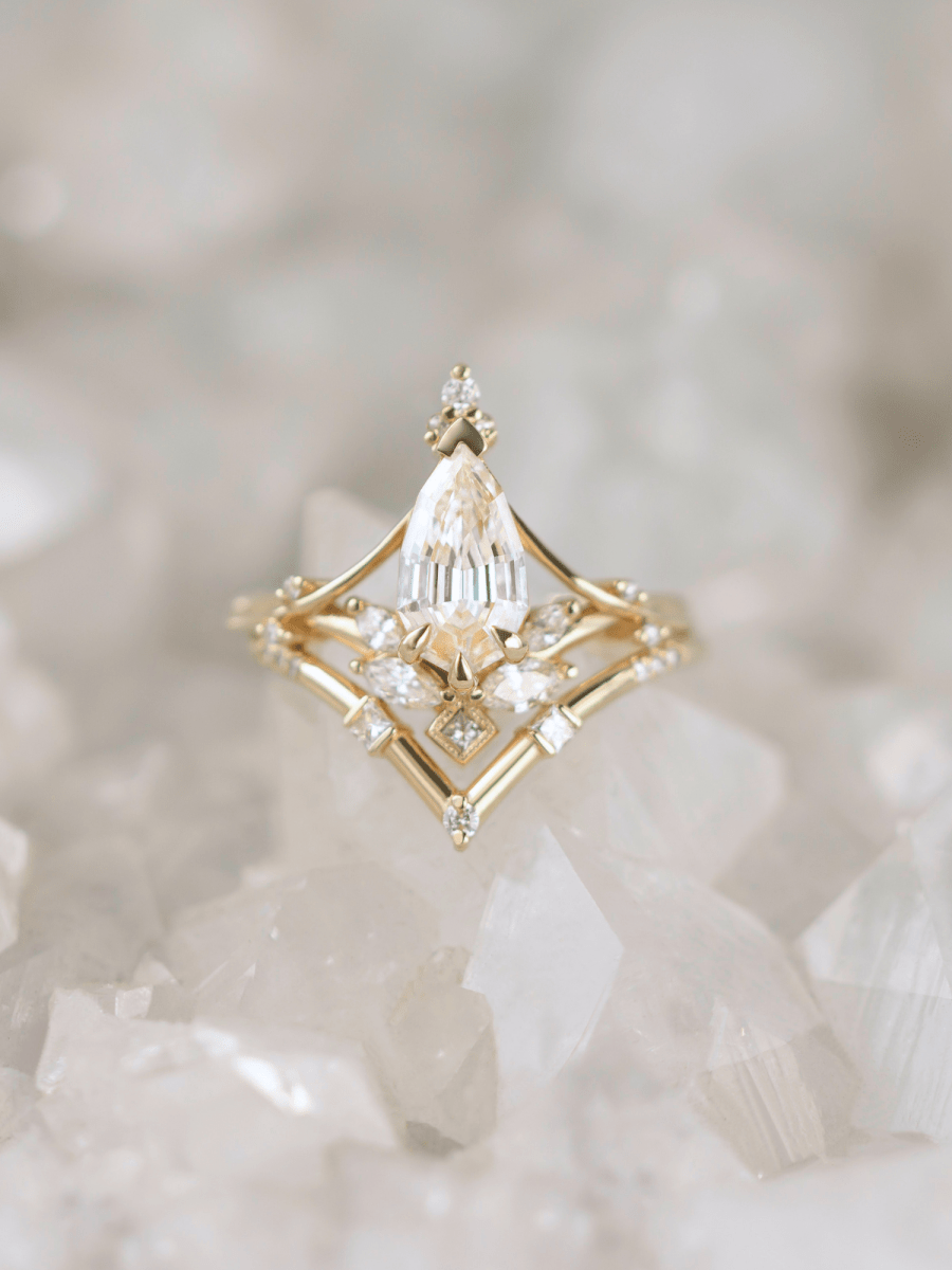 Front view of Art Nouveau engagement ring with marquise diamond, split shank, and chevron band on rough white crystal