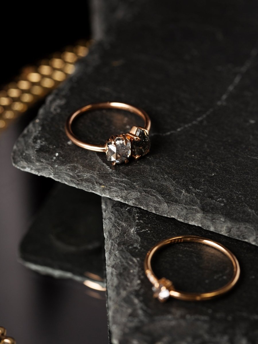 Gold ring with a diamond on a dark stone surface