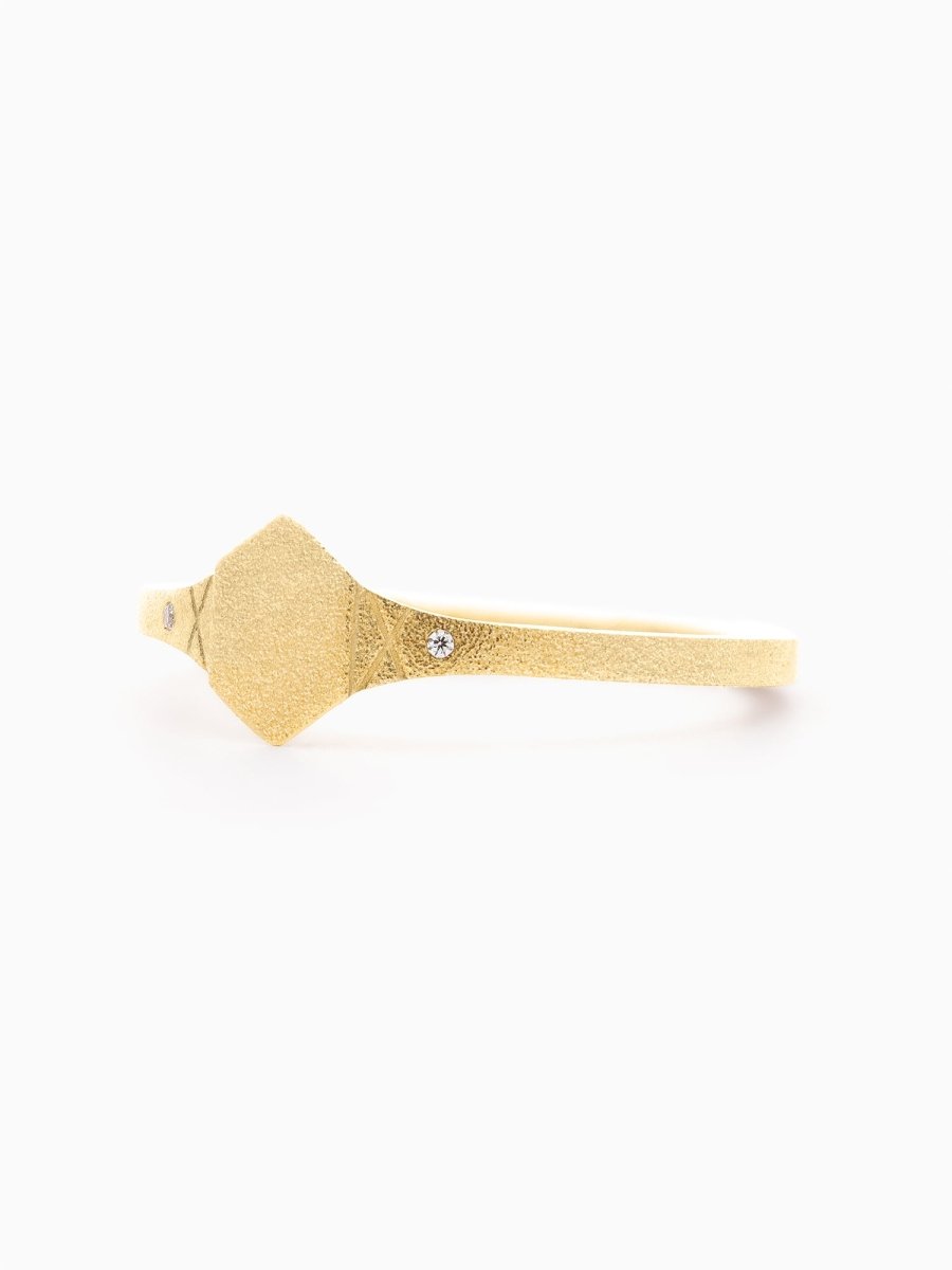 Side profile of gold ring showing tapered band and knife-edge transition from hexagon signet