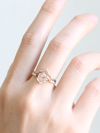 Hexagon rutilated quartz engagement ring in 14k rose gold with smaller baguette and round diamonds inspired by the art deco style and minimalism.