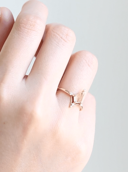 Kite shape rutilated quartz engagement ring with smaller round diamonds in 14k gold inspired by the art deco style and minimalism.