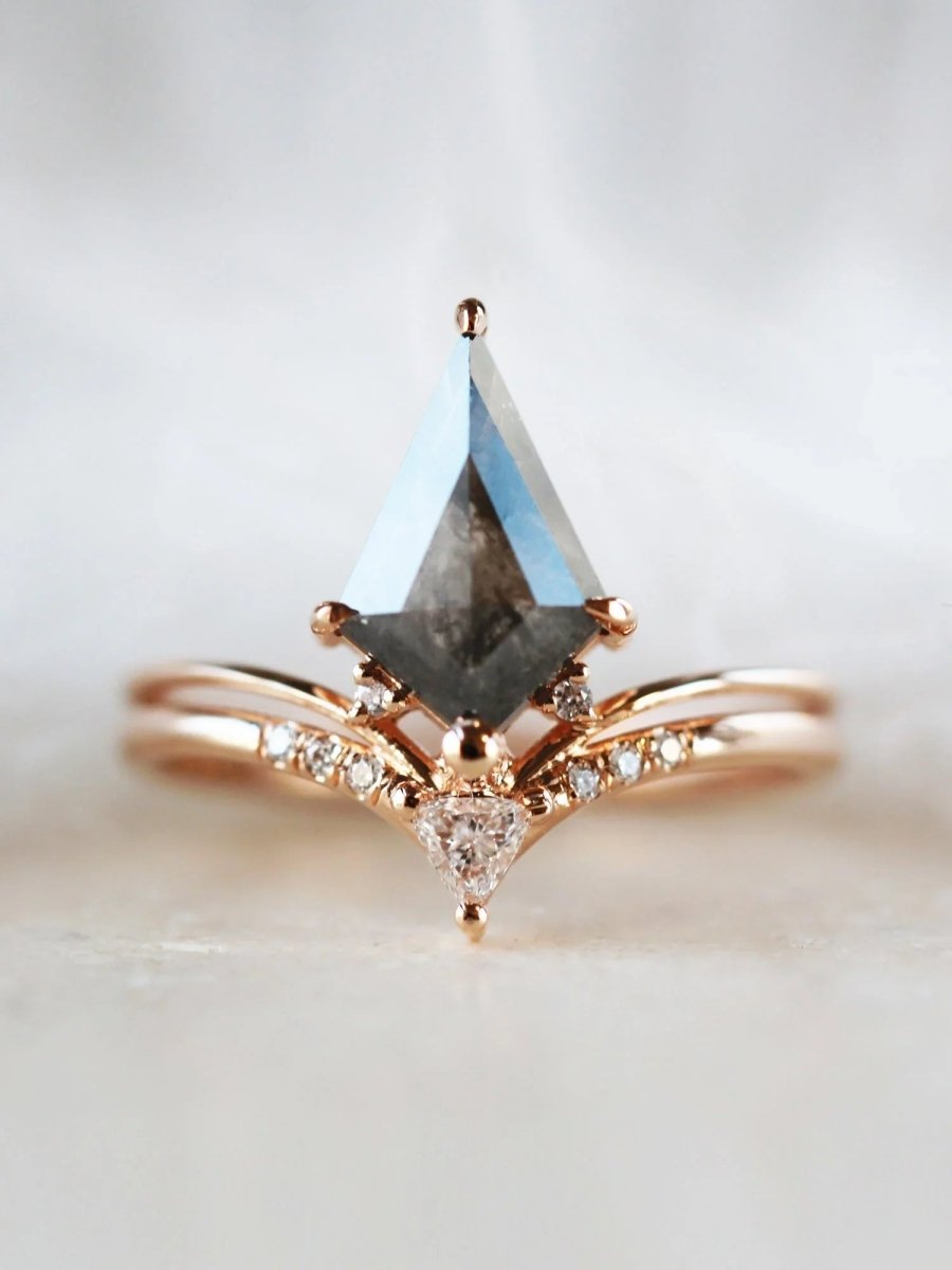 Minimalistic and art deco styled kite salt and pepper diamond engagement ring in 14k rose gold with a trilliant and round diamonds.
