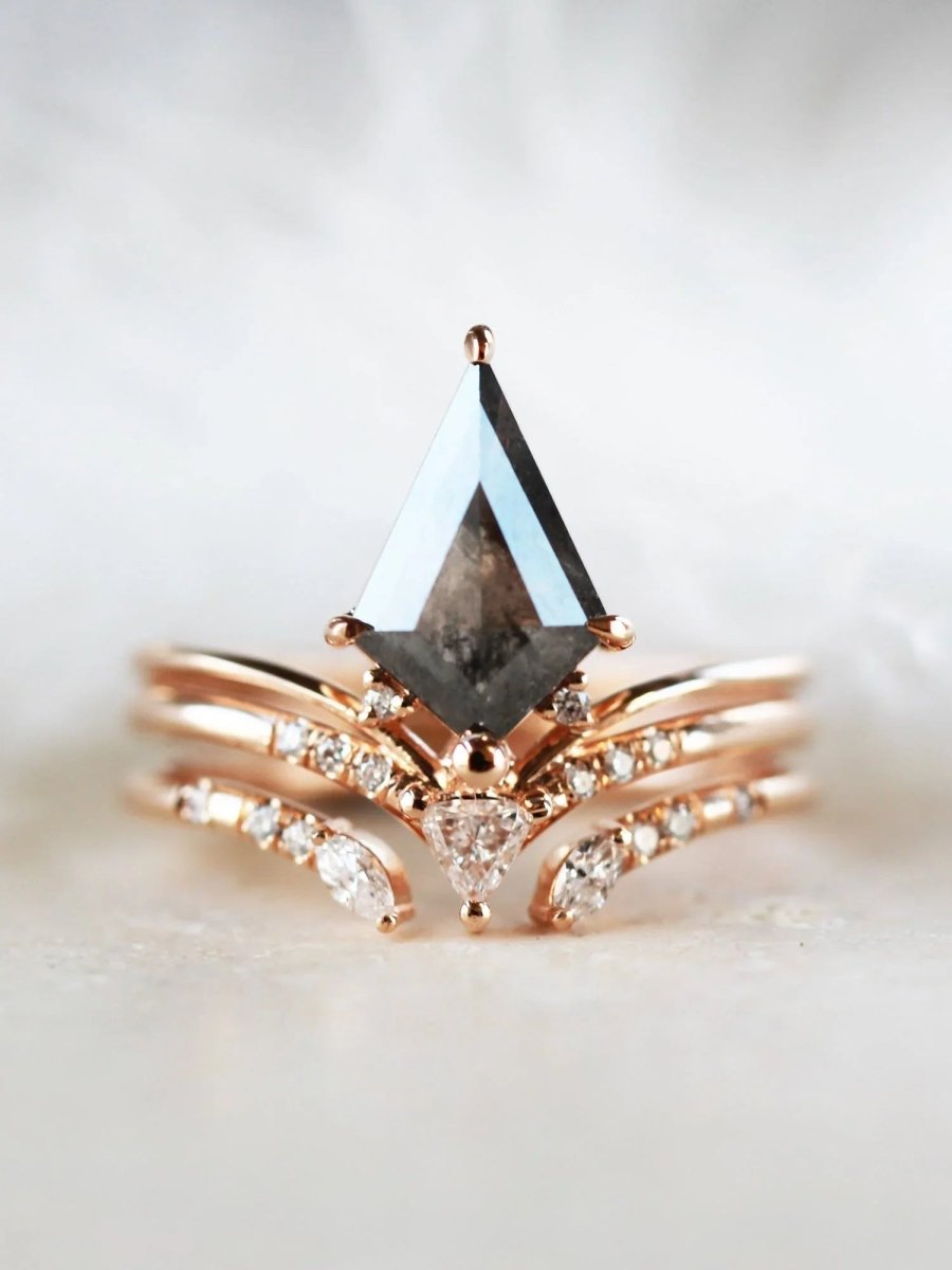 Minimalistic and art deco styled kite salt and pepper diamond engagement ring in 14k rose gold with a trilliant and round diamonds with matching band.