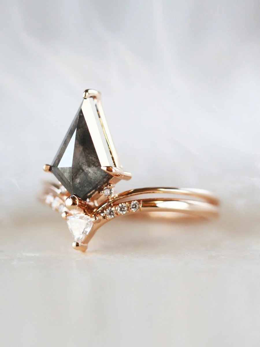 Minimalistic and art deco styled kite salt and pepper diamond engagement ring in 14k rose gold with a trilliant and round diamonds.