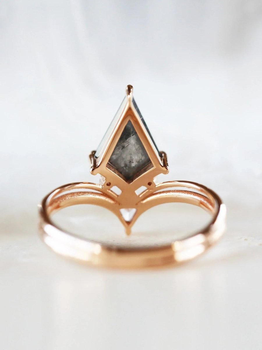 Minimalistic and art deco styled kite salt and pepper diamond engagement ring in 14k rose gold with a trilliant and round diamonds.