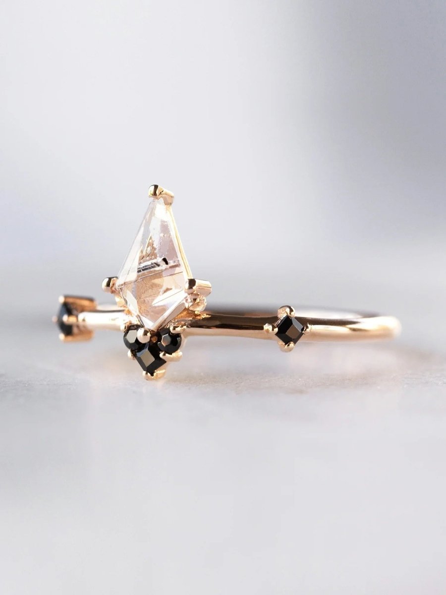 3/4 view of minimalist Art Deco ring in sunlight, showing kite tourmalinated center and onyx accents with natural sparkle
