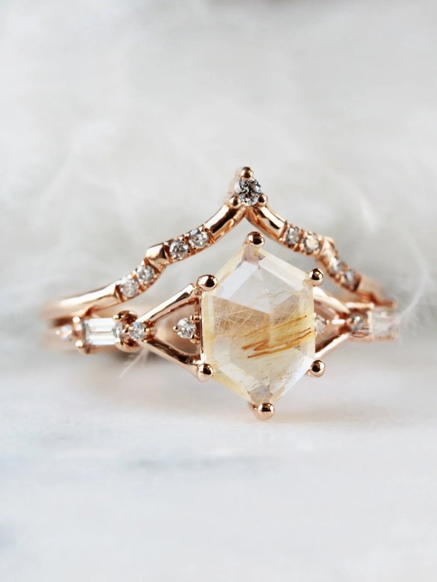Hexagon rutilated quartz engagement ring in 14k rose gold with smaller baguette and round diamonds inspired by the art deco style and minimalism.