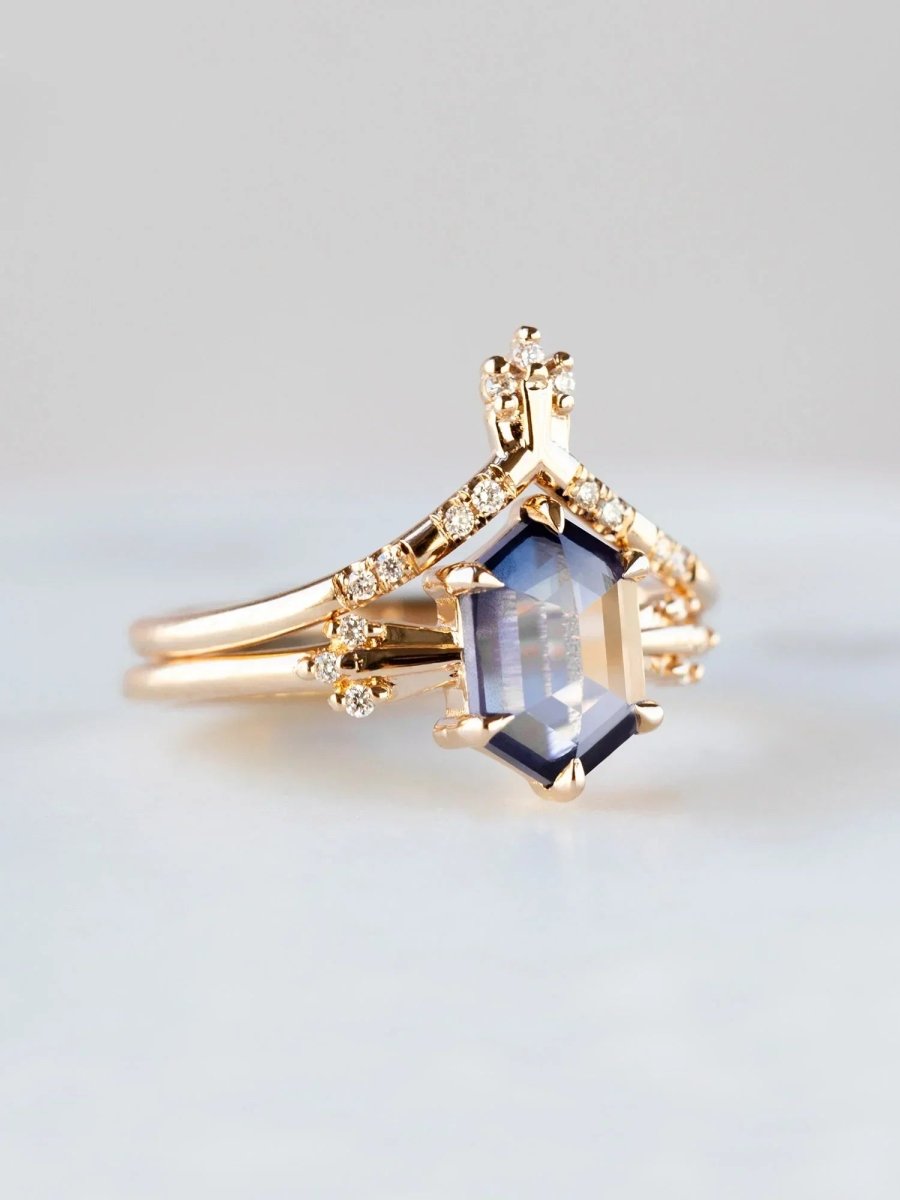Gold ring with a blue gemstone on a light gray background
