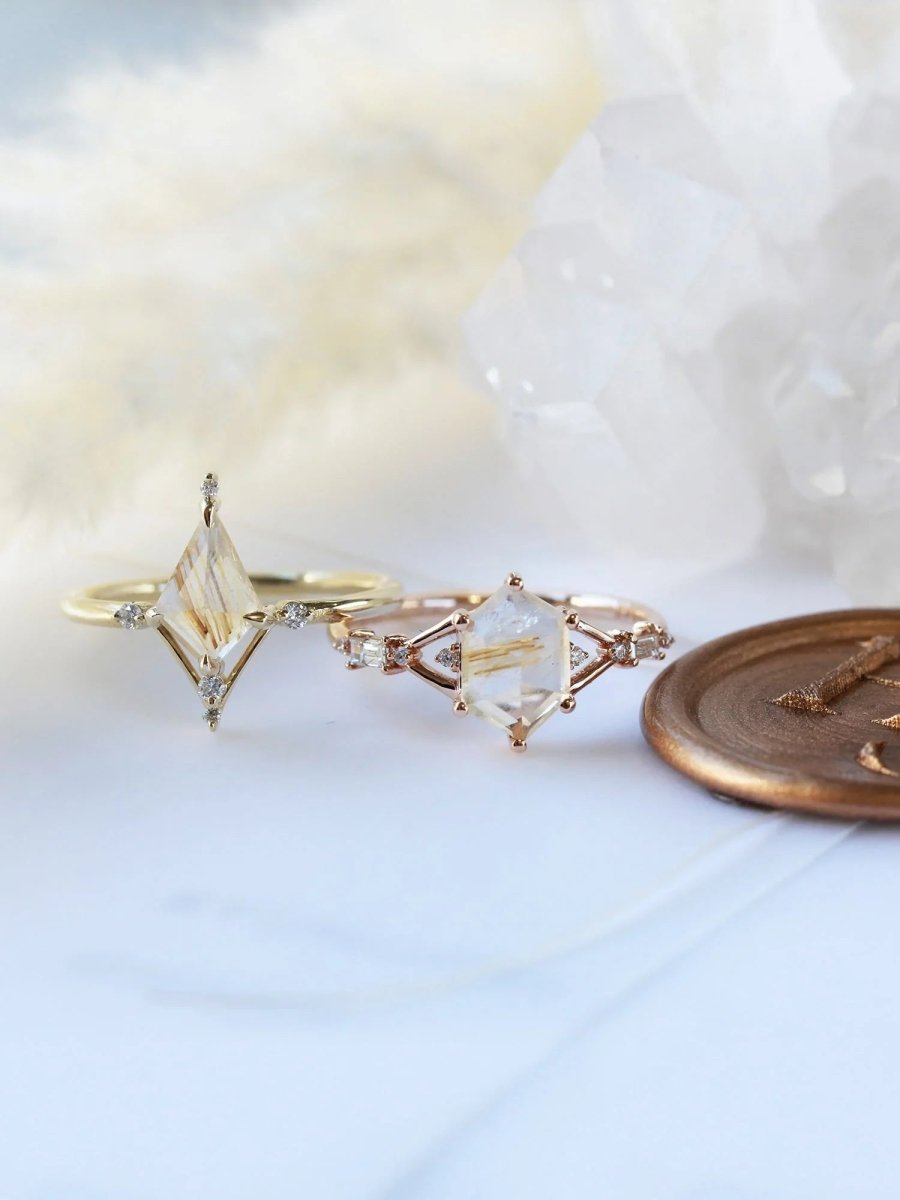 Kite shape rutilated quartz engagement ring with smaller round diamonds in 14k gold inspired by the art deco style and minimalism.