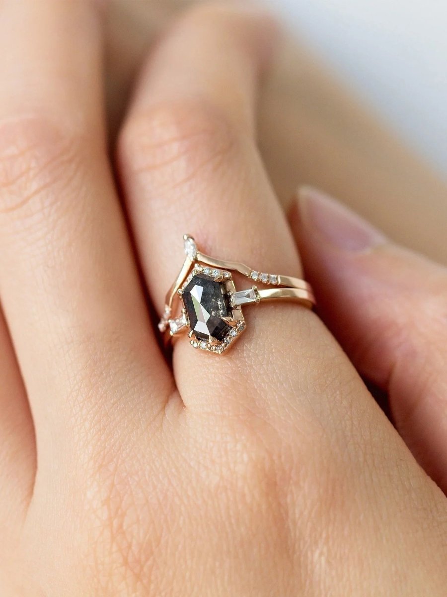 Unique art deco styled hexagon salt and pepper diamond engagement ring in 14k rose gold with baguette and round diamonds on model's hand.