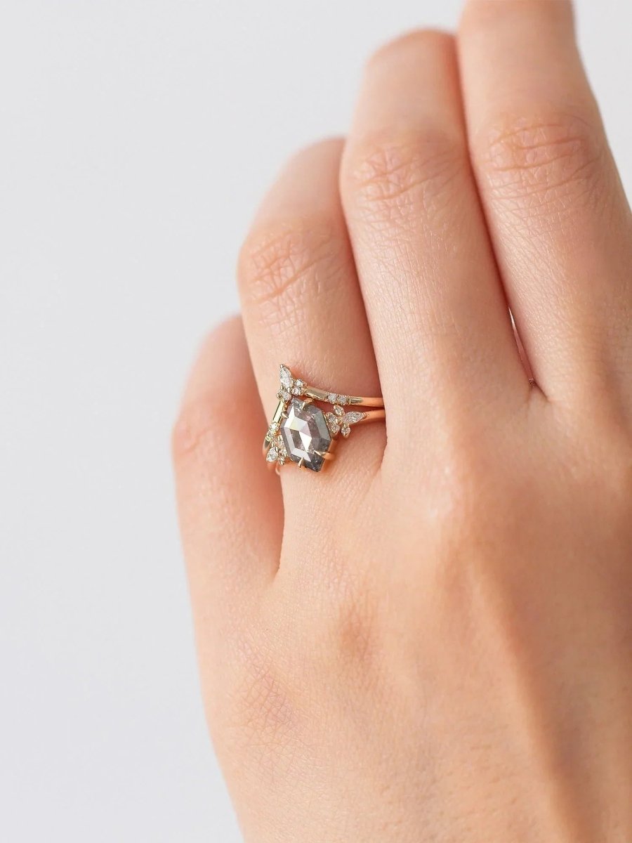 Gold ring with a diamond on a hand against a light background
