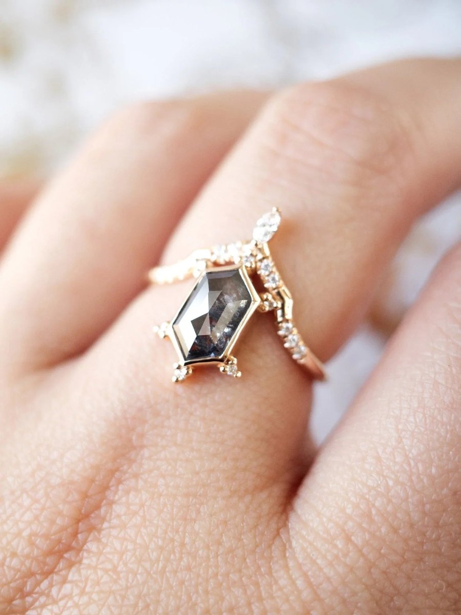 Unique art deco styled hexagon salt and pepper diamond engagement ring in 14k rose gold with a marquise and round diamonds on model's hand.