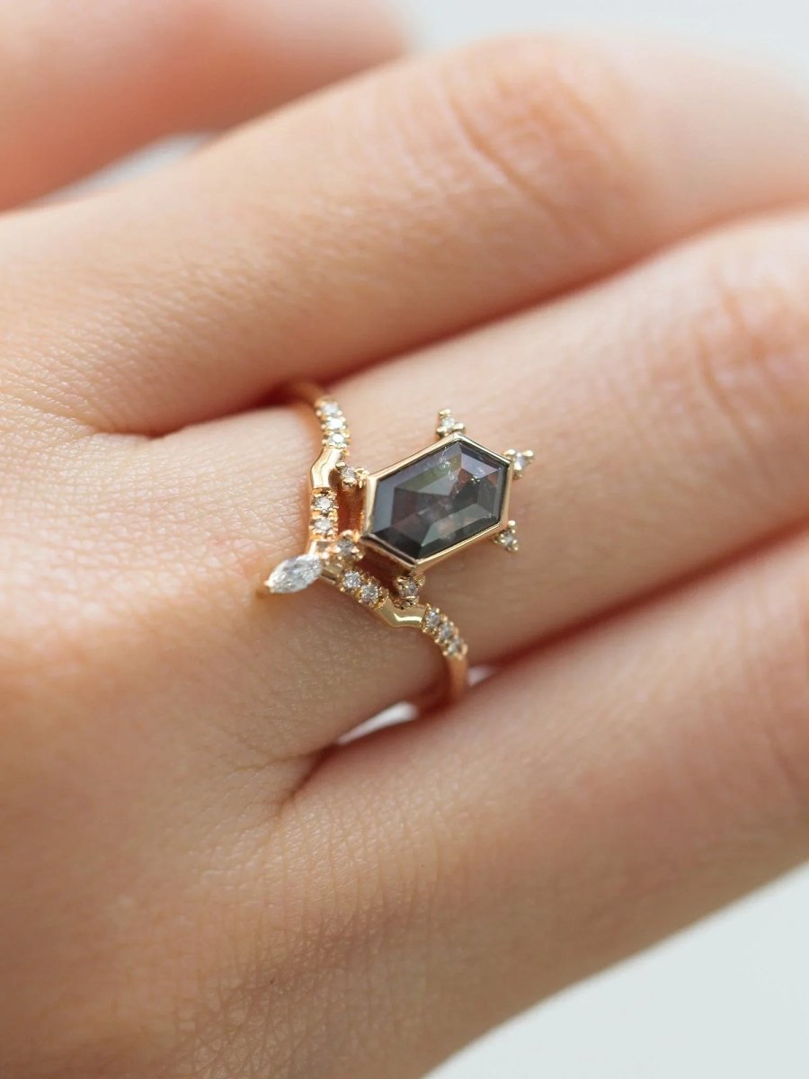 Unique art deco styled hexagon salt and pepper diamond engagement ring in 14k rose gold with a marquise and round diamonds on model's hand.