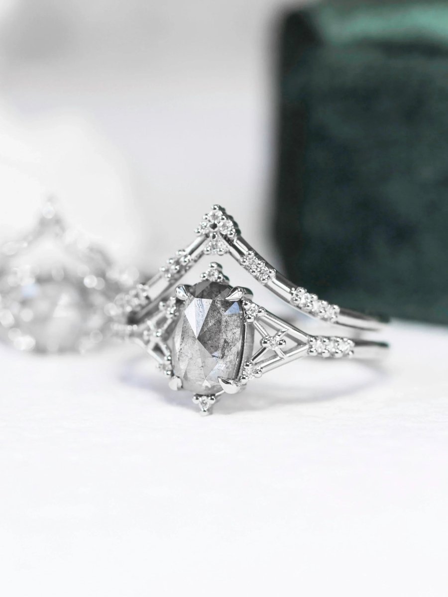 Art deco minimalistic oval salt and pepper diamond engagement ring in 14k rose gold with smaller round diamonds.