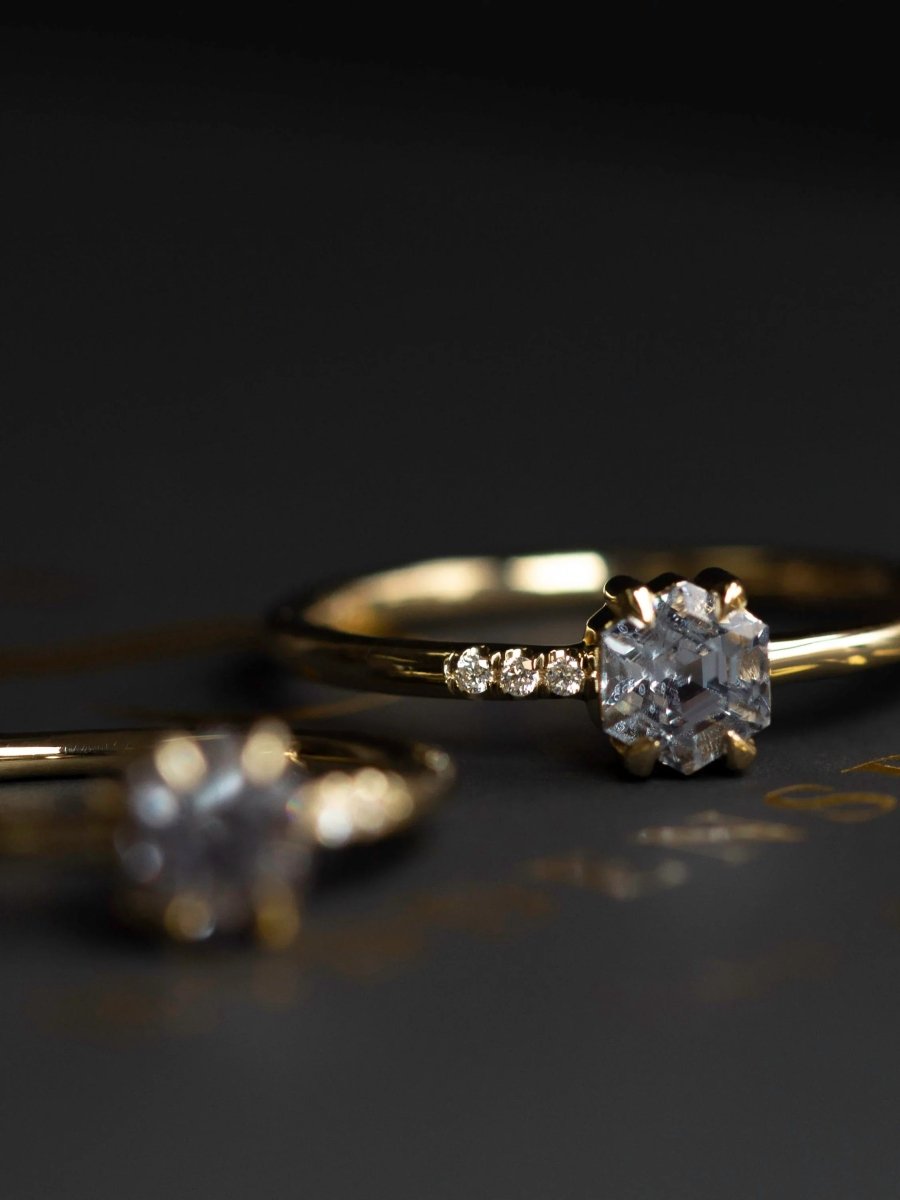 Gold rings with diamond accents on a dark surface