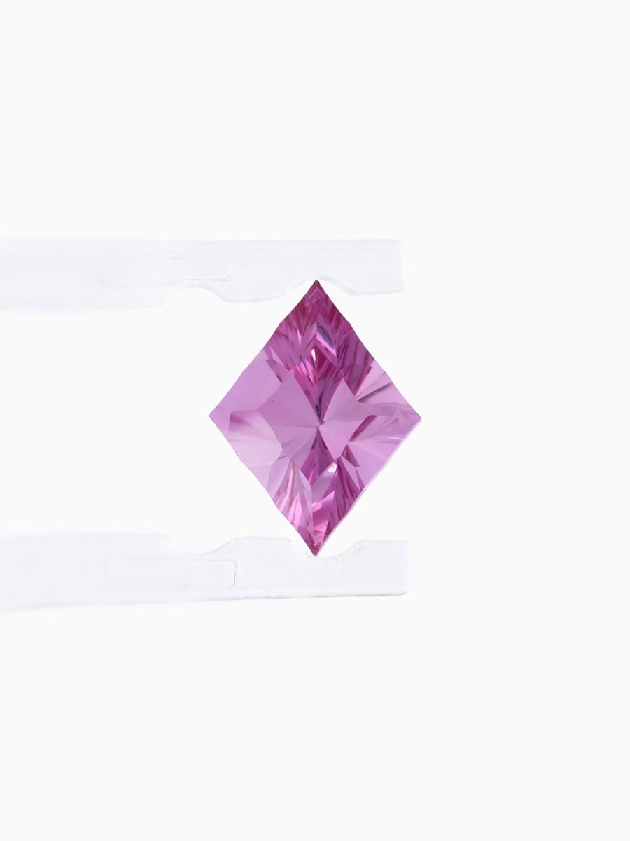 face view of designer cut burgundy kite sapphire held between tweezers on a white background