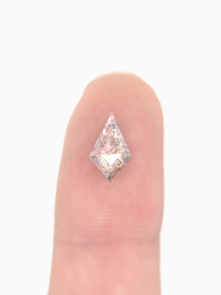  Loose kite-shaped rose salt and pepper diamond with autumn-colored inclusions, shown on fingertip for scale