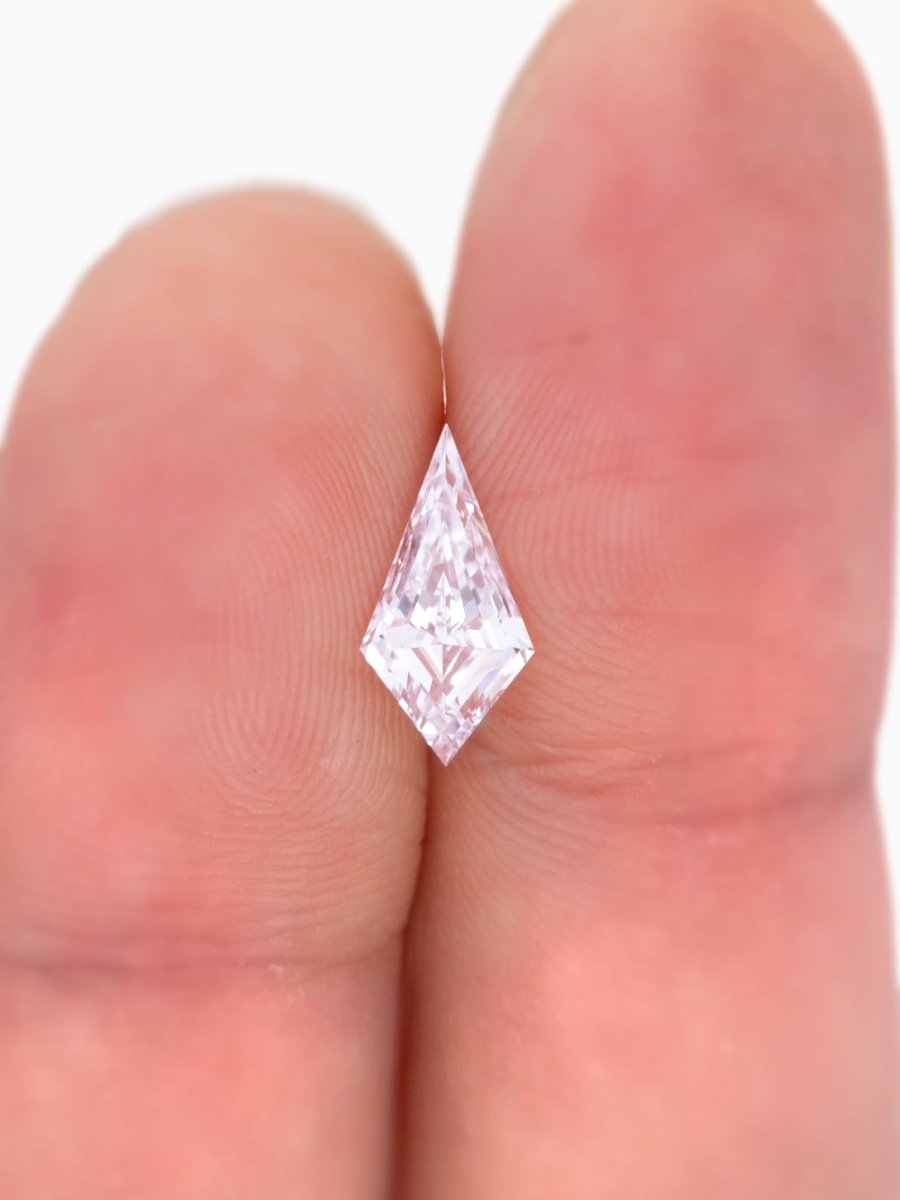 Diamond held between two fingers against a white background