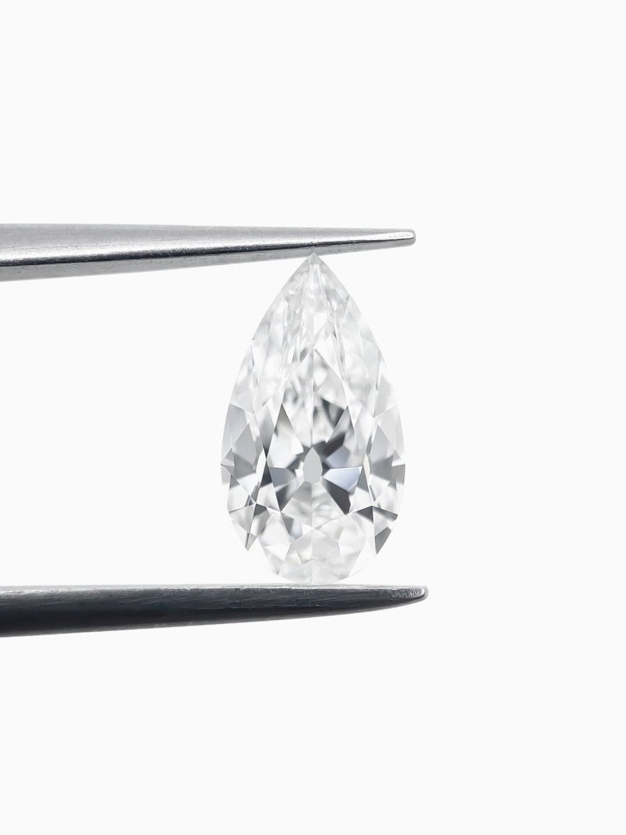 Pear-shaped diamond held between tweezers on a white background