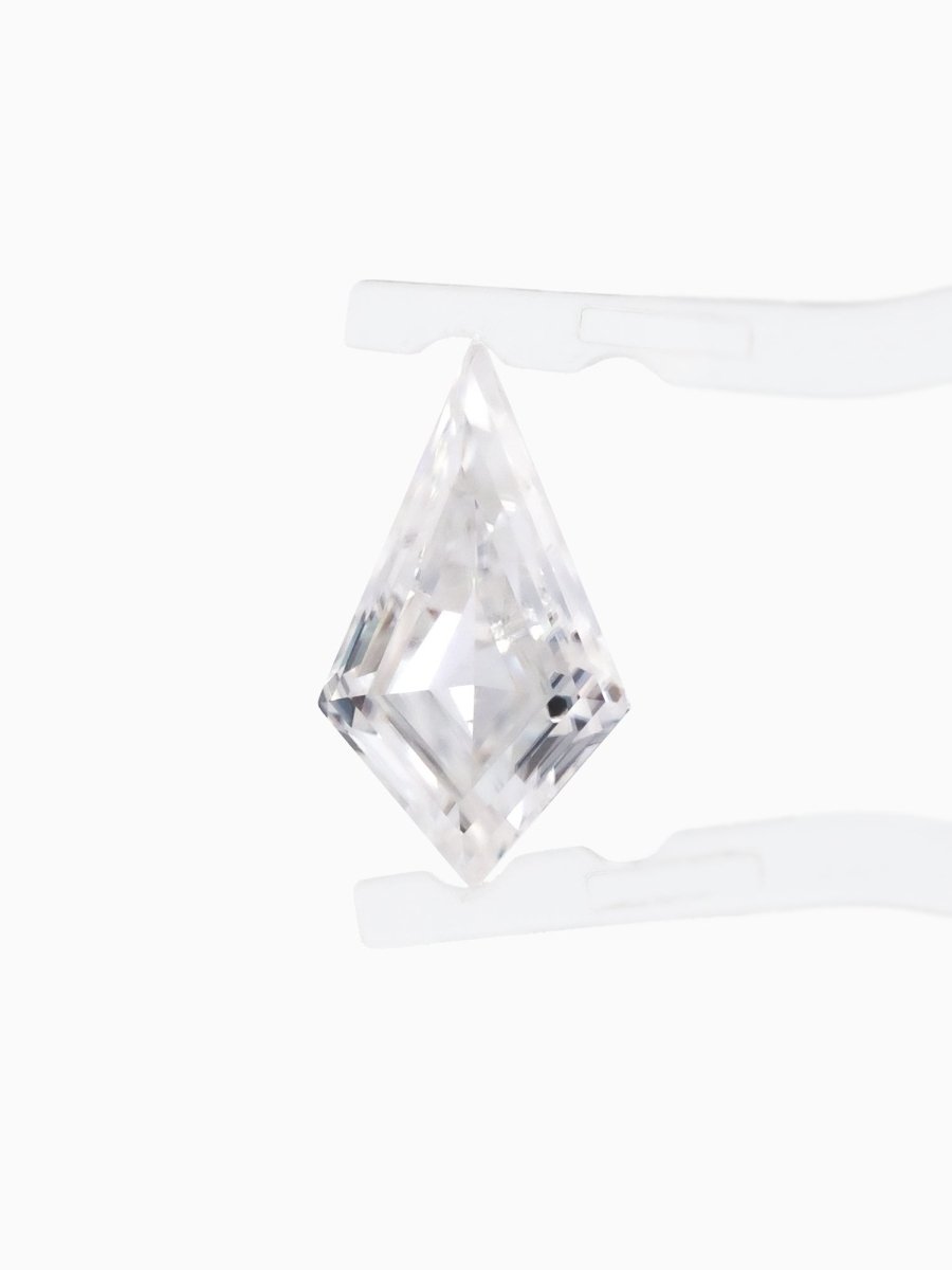 top view of loose lab-grown kite moissanite gemstone held by tweezers, sustainable and conflict-free