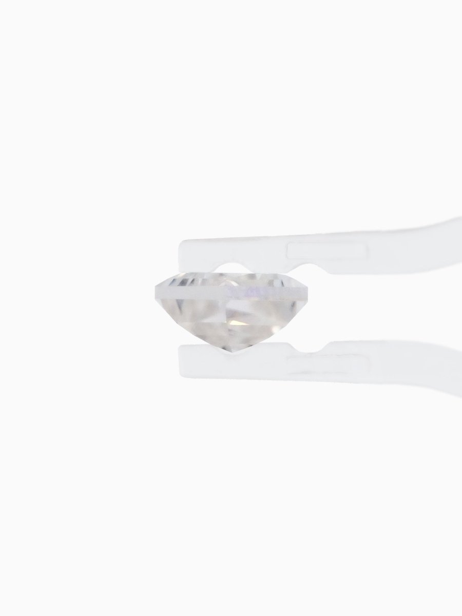profile view of loose lab-grown kite moissanite gemstone held by tweezers, sustainable and conflict-free