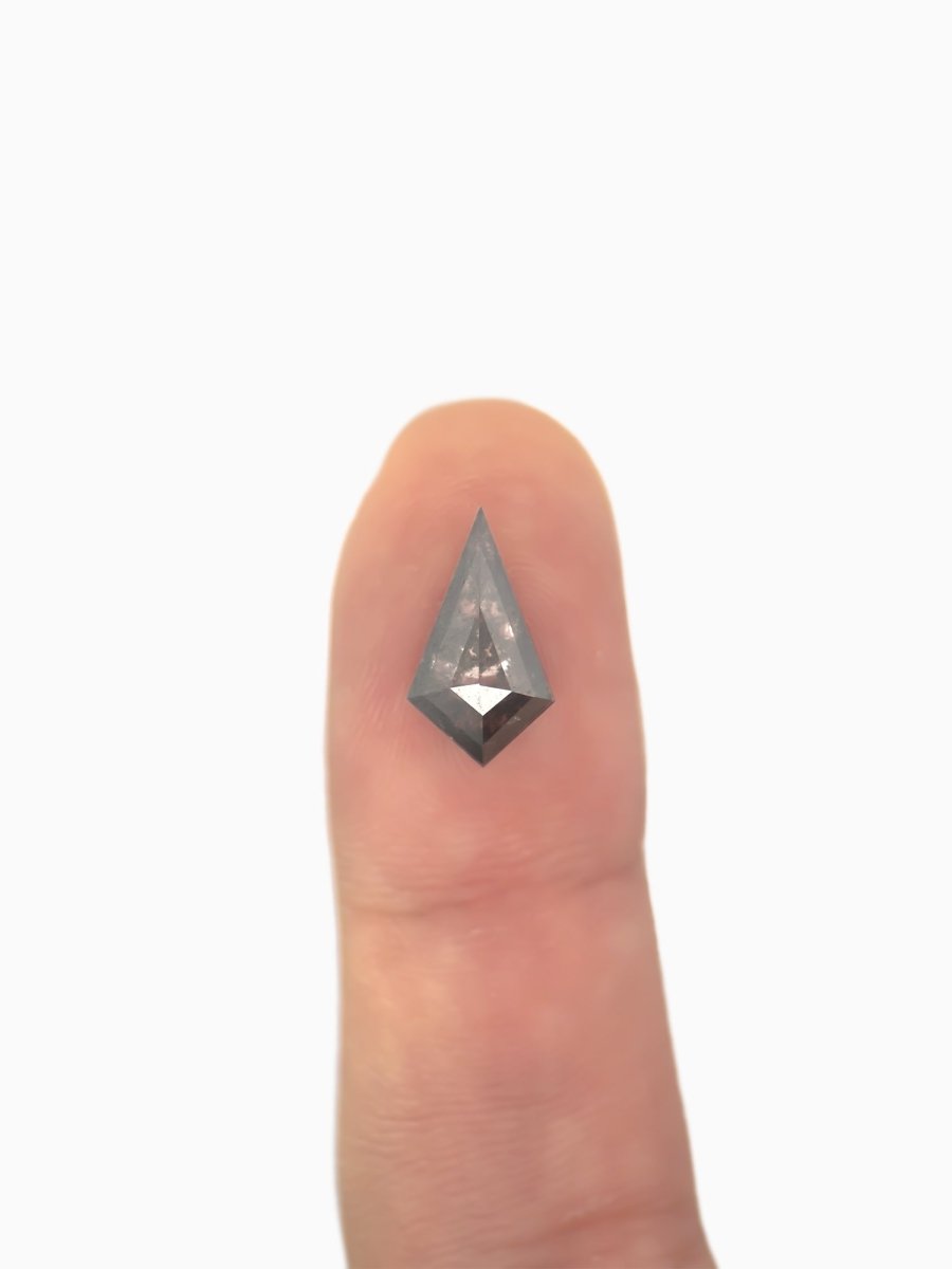  loose lab-grown kite salt pepper diamond gemstone on fingertip for scale