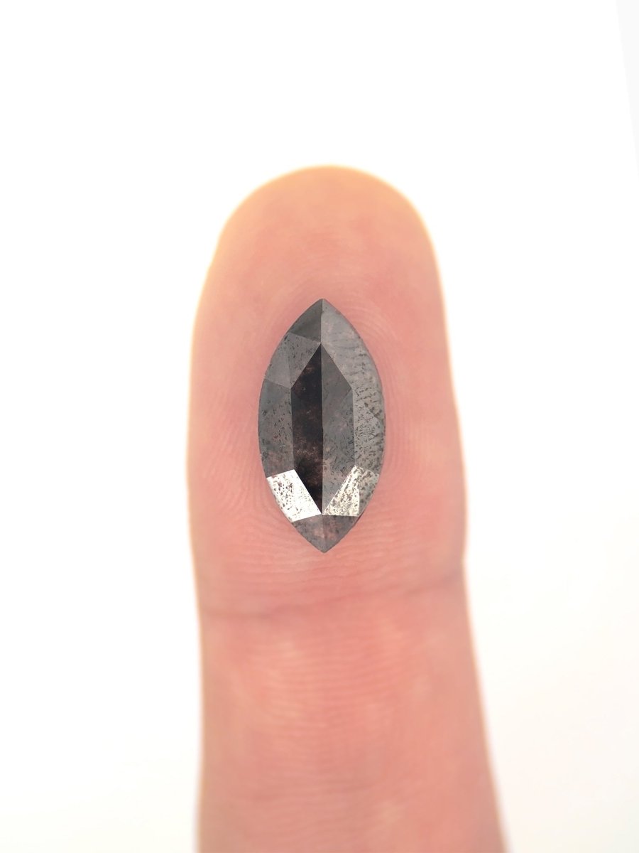 face view of loose lab-grown hexagon salt pepper diamond gemstone on finger for scale