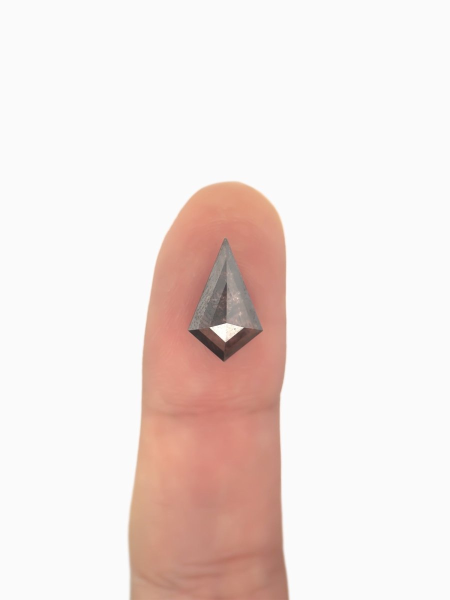  loose lab-grown kite salt pepper diamond gemstone on fingertip for scale