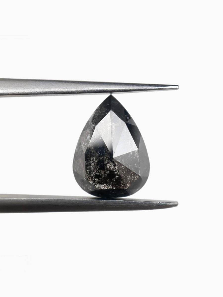 sustainable lab-grown pear shaped salt pepper diamond between tweezers