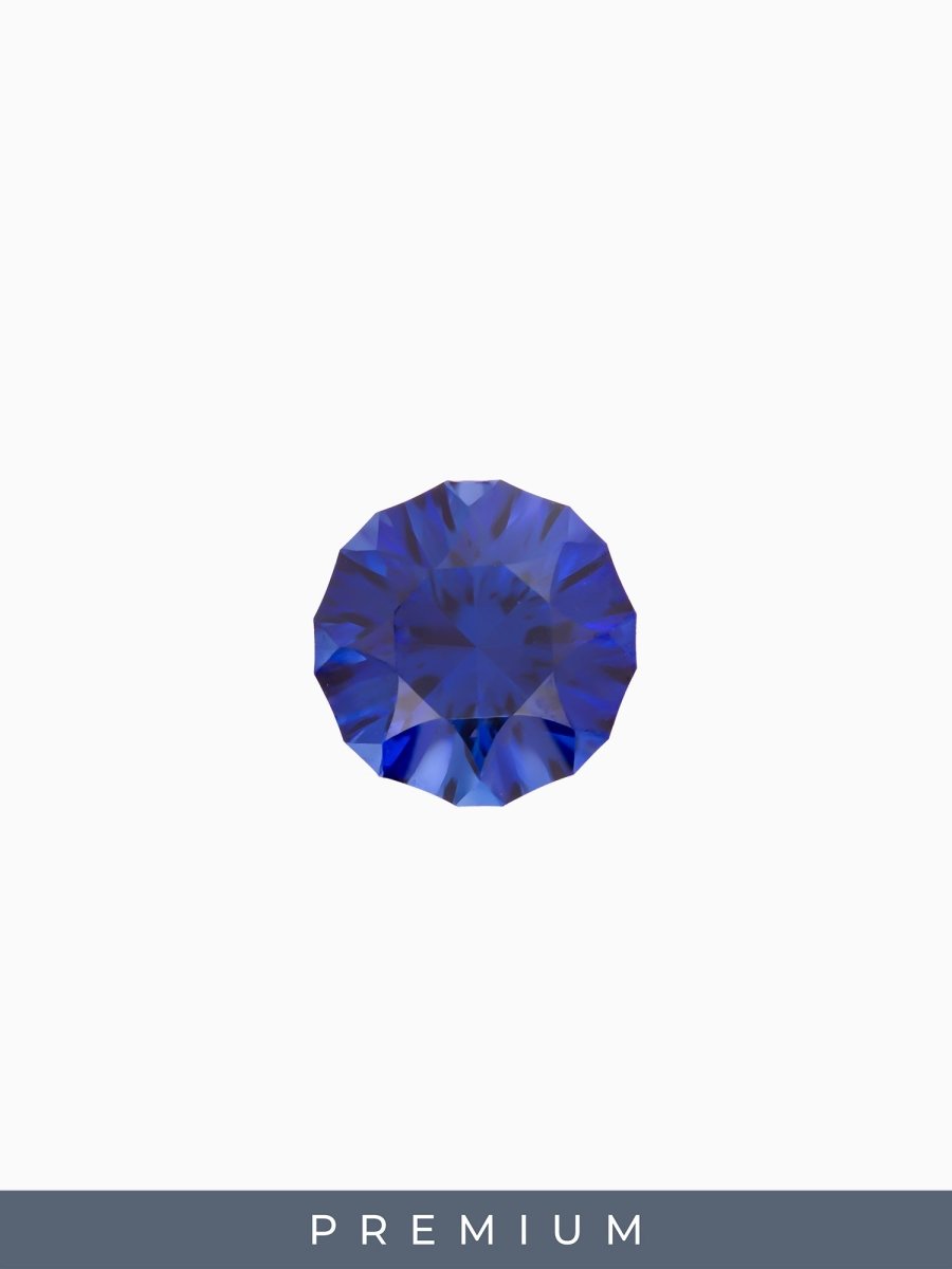 face view of designer cut blue round sapphire on a white background with premium label