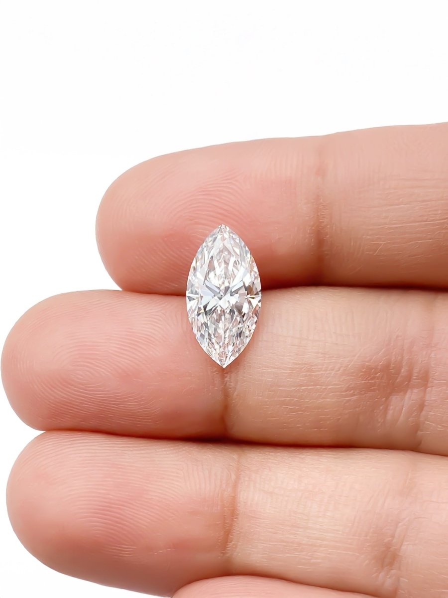 Marquise-shaped diamond held between fingers on a white background for scale