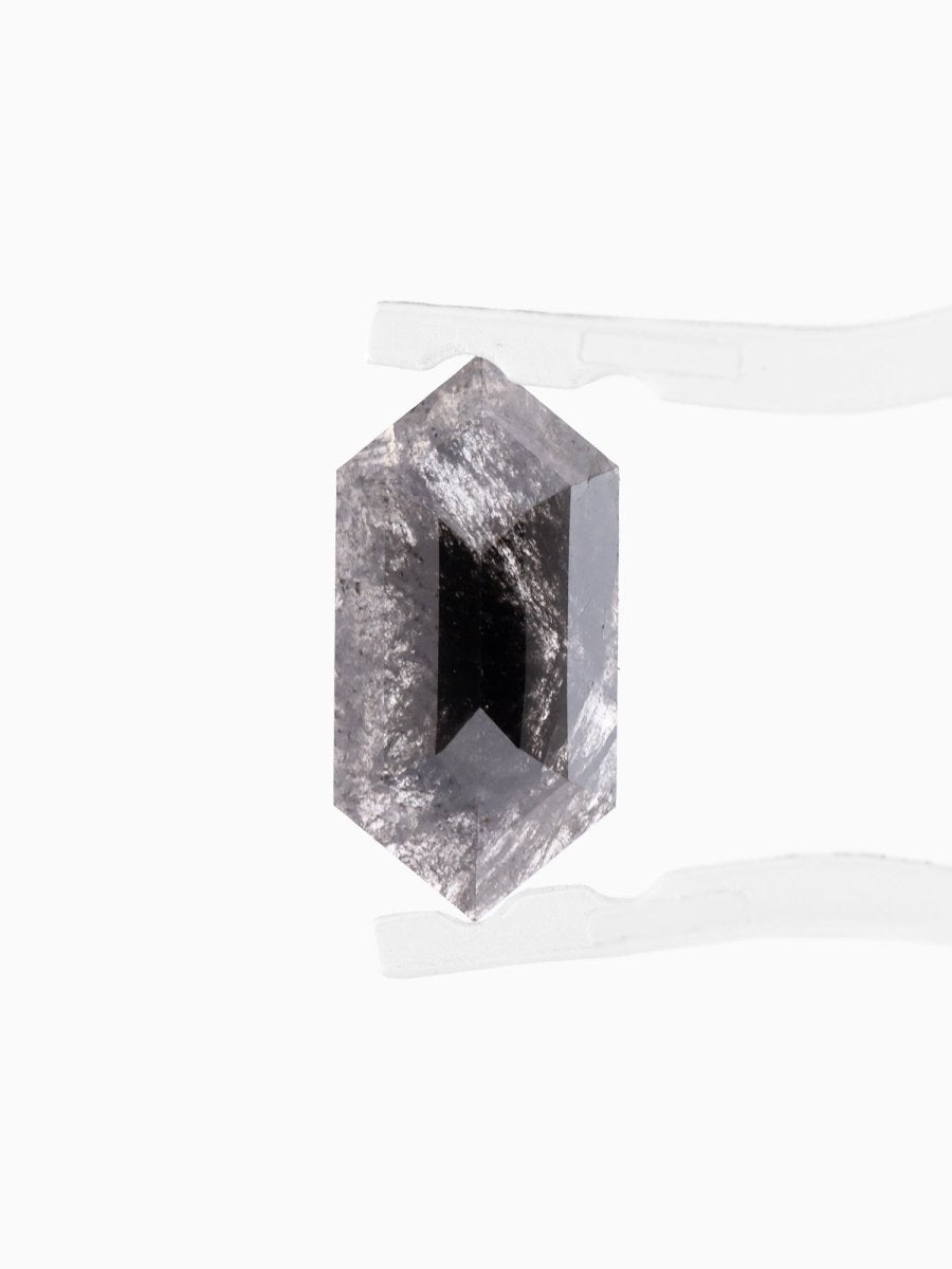 face view of loose lab-grown hexagon salt pepper diamond gemstone between tweezers