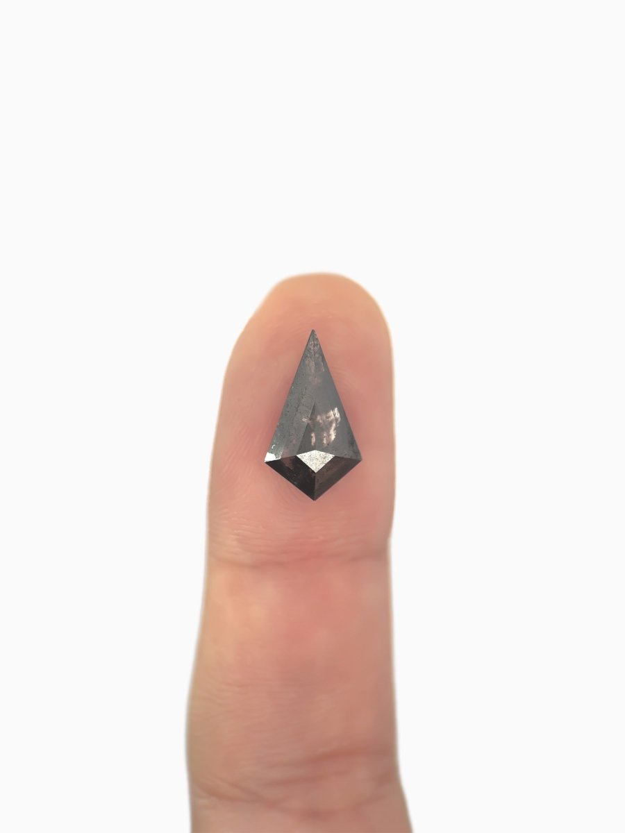  loose lab-grown kite salt pepper diamond gemstone on fingertip for scale