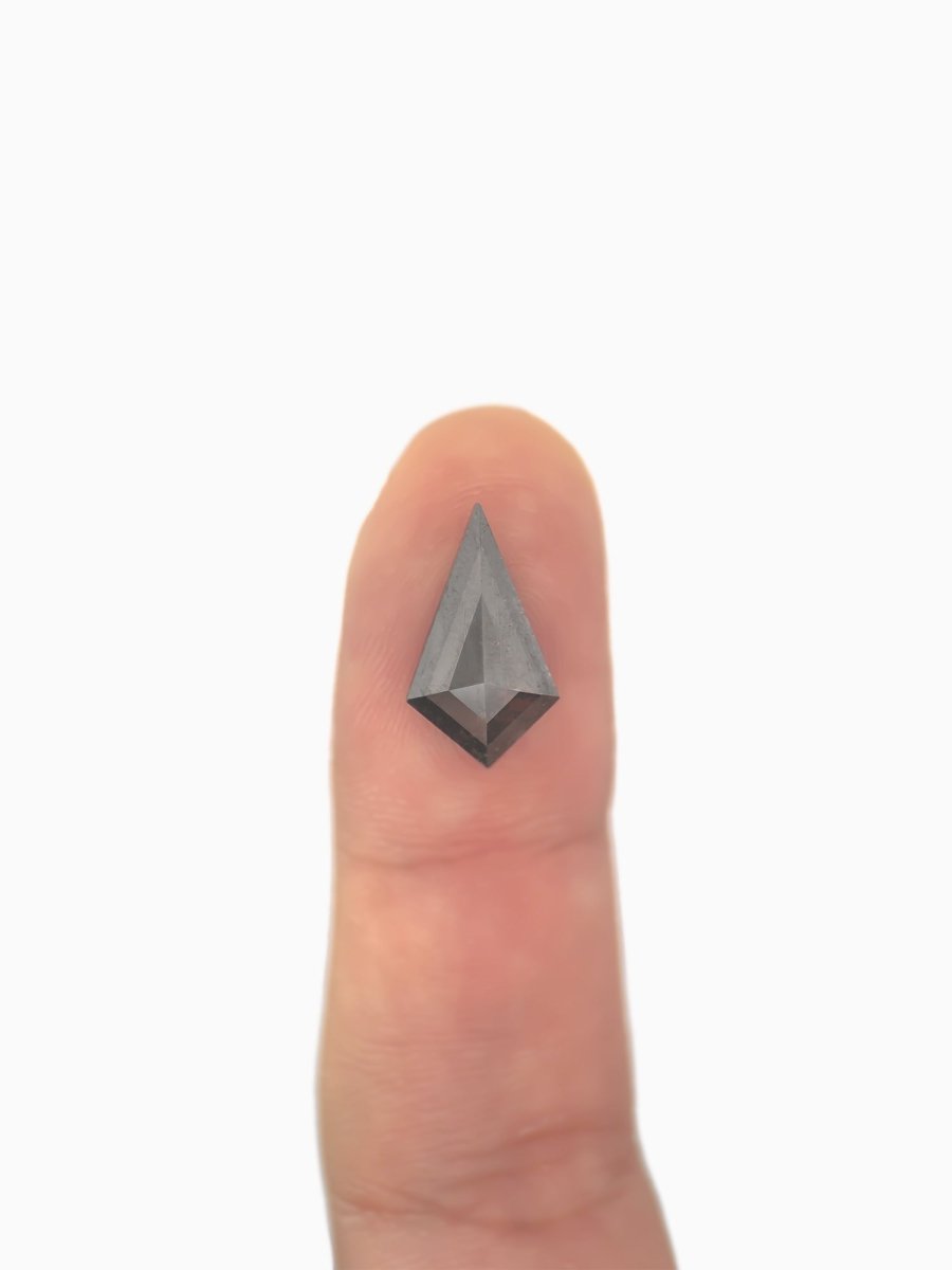  loose lab-grown kite salt pepper diamond gemstone on fingertip for scale