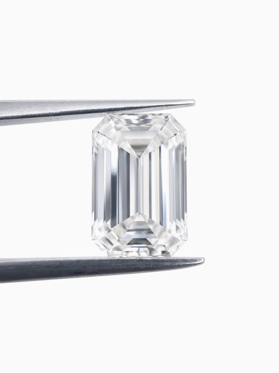 emerald shape lab grown sustainable diamond held by tweezers on a white background