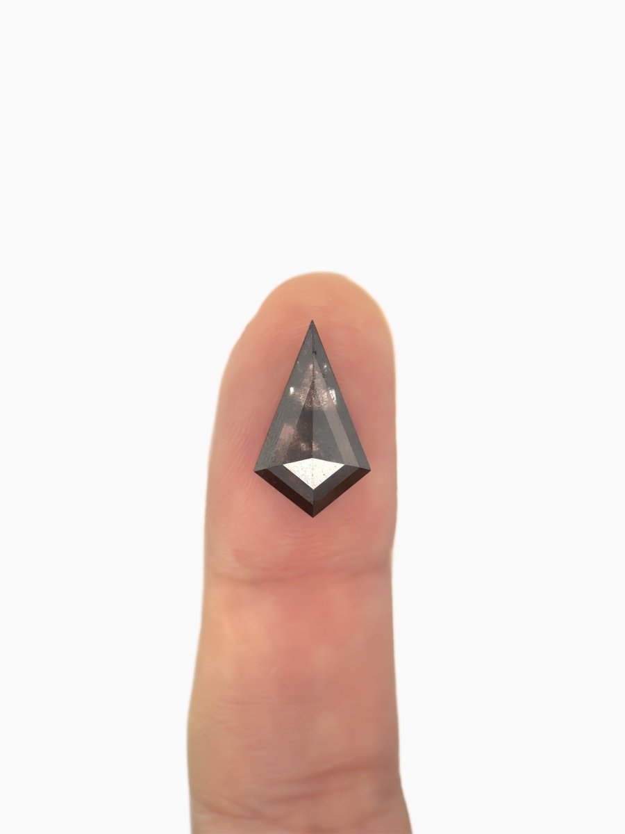  loose lab-grown kite salt pepper diamond gemstone on fingertip for scale