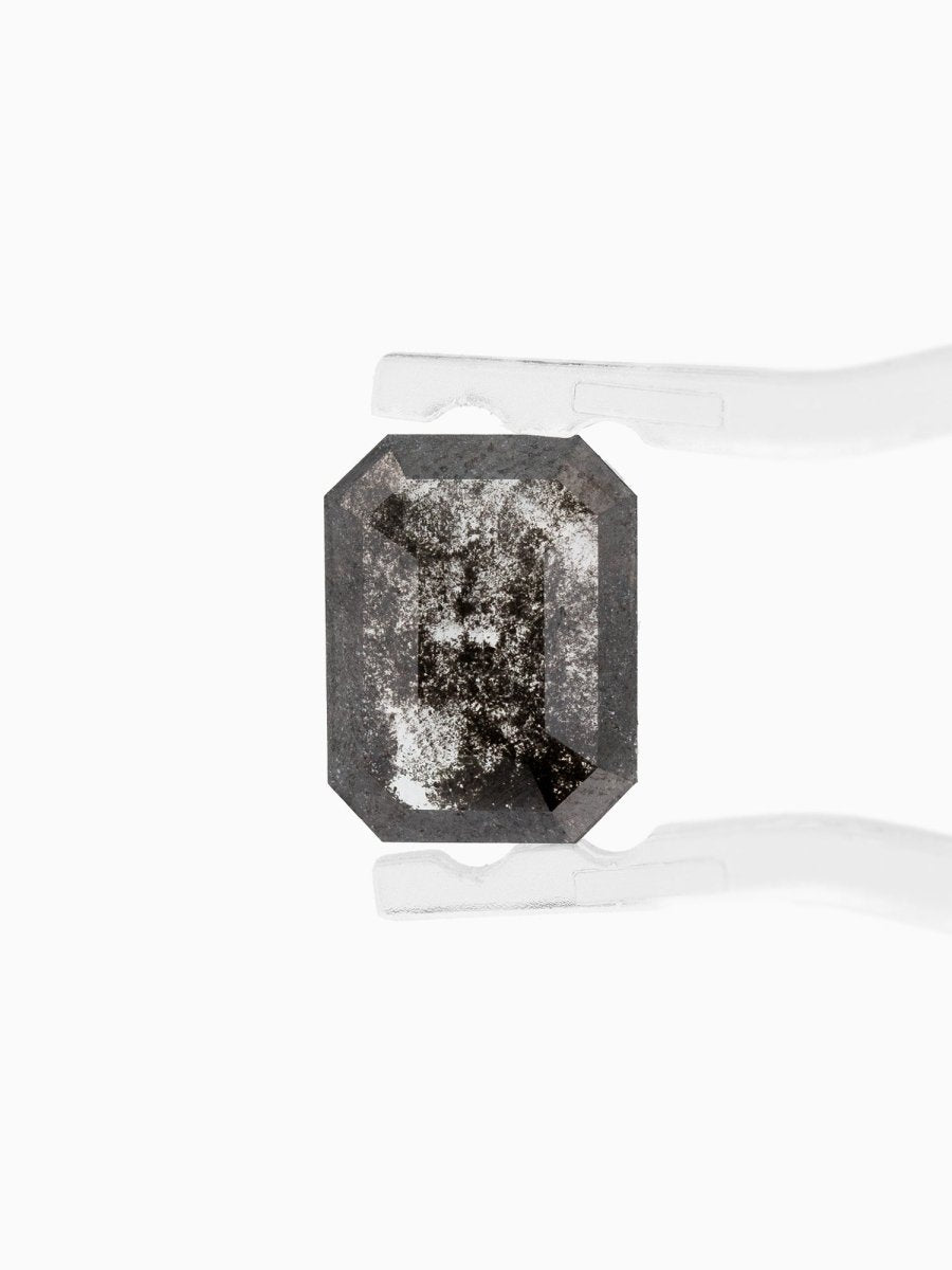 face view of loose lab-grown emerald-cut salt pepper diamond gemstone held by tweezers