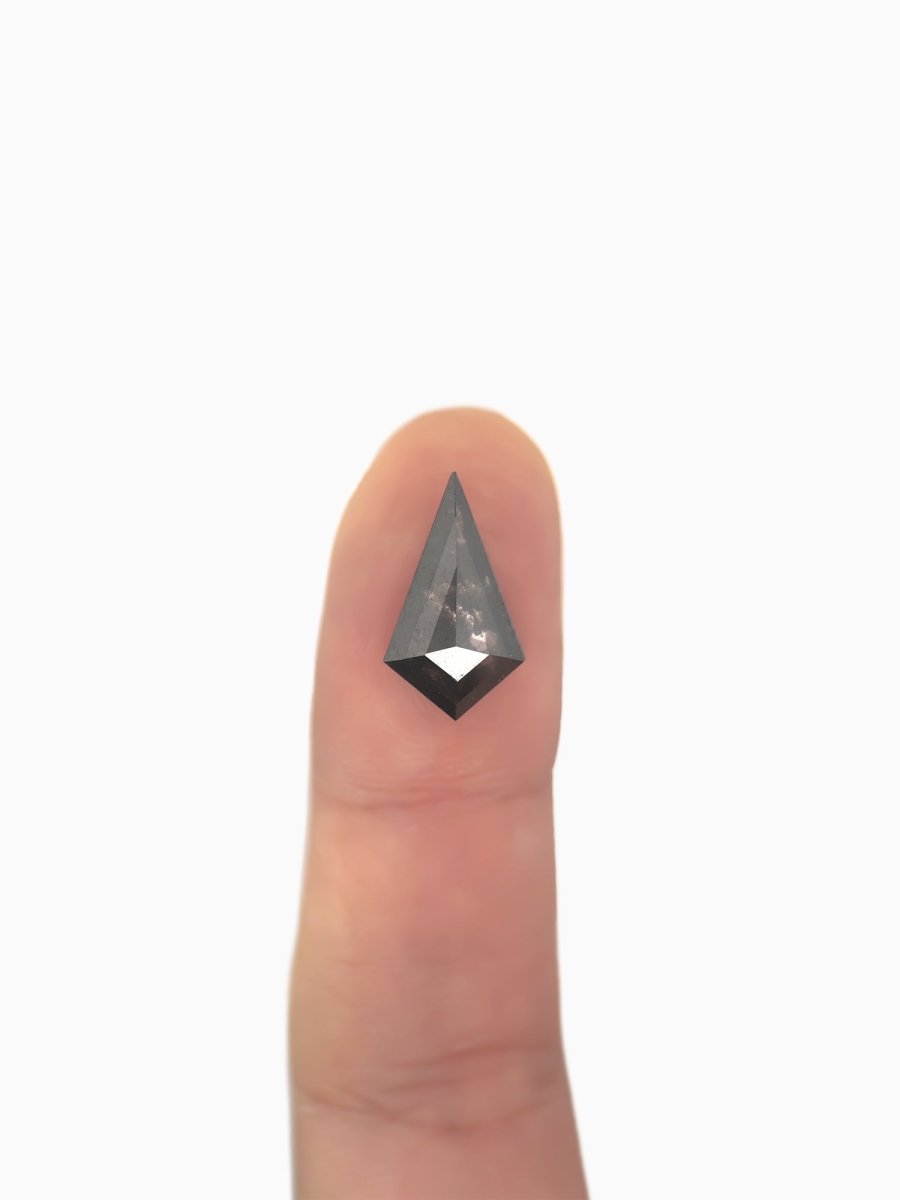  loose lab-grown kite salt pepper diamond gemstone on fingertip for scale