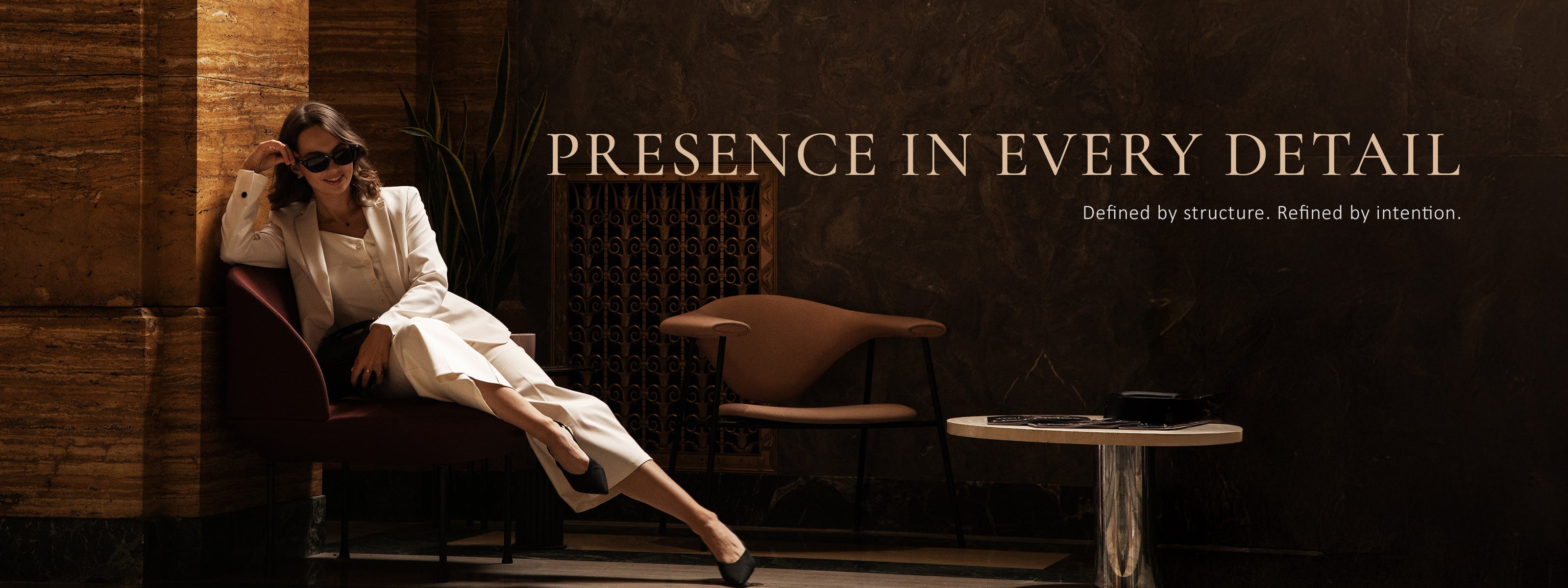 A woman sitting in a chair. Elegant women win white suit 