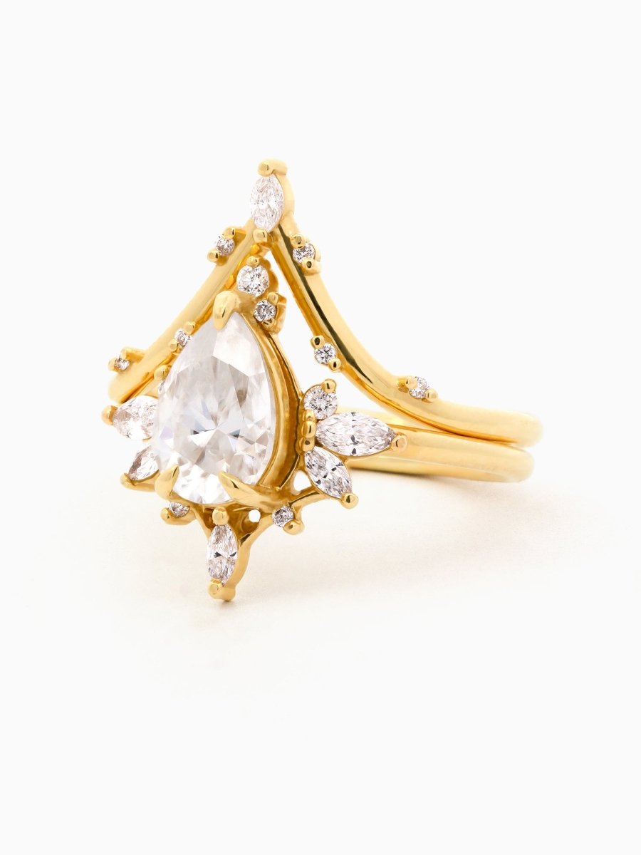 Gold ring with a pear-shaped diamond on a light background