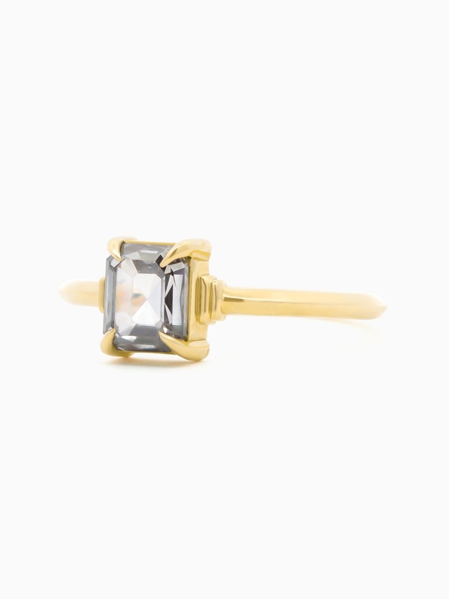 Gold ring with a clear gemstone on a white background