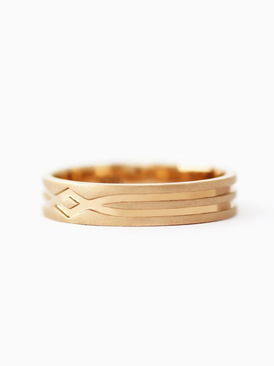 Gold ring with a textured design on a white background