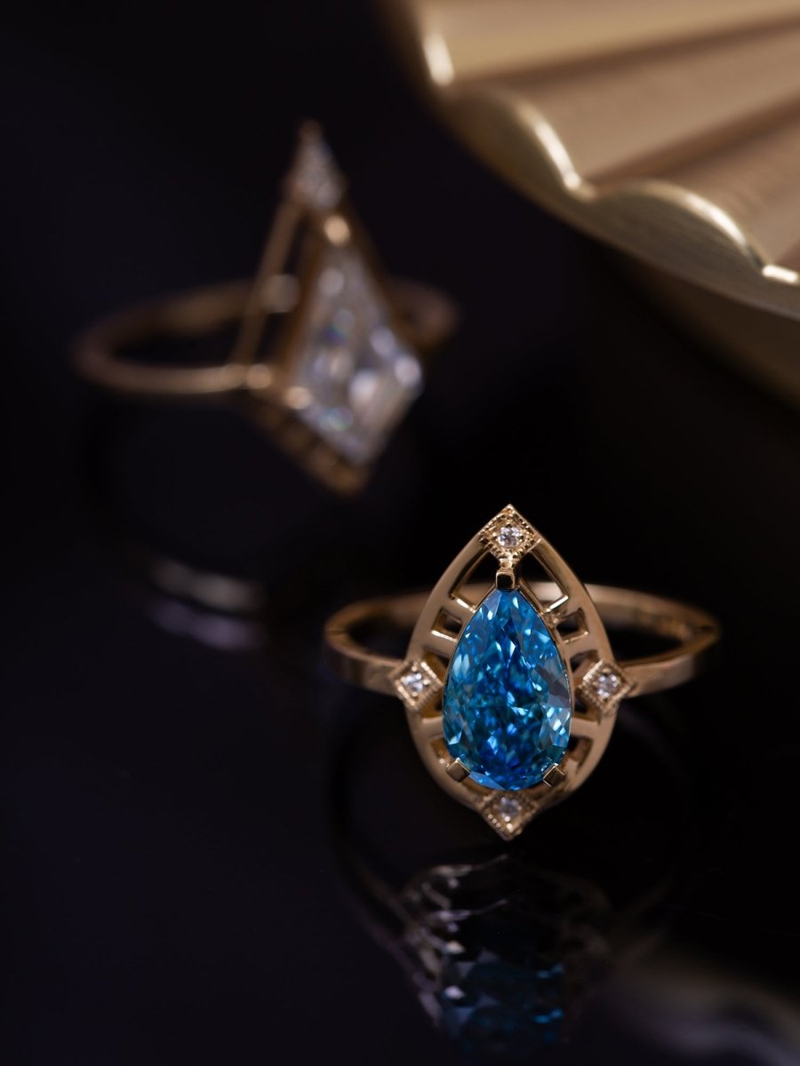Gold ring with a blue diamond on a dark background