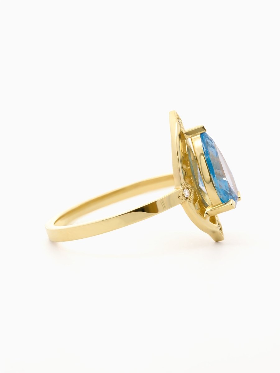 Side view of ring showing floating pear-cut blue diamond above open gold base