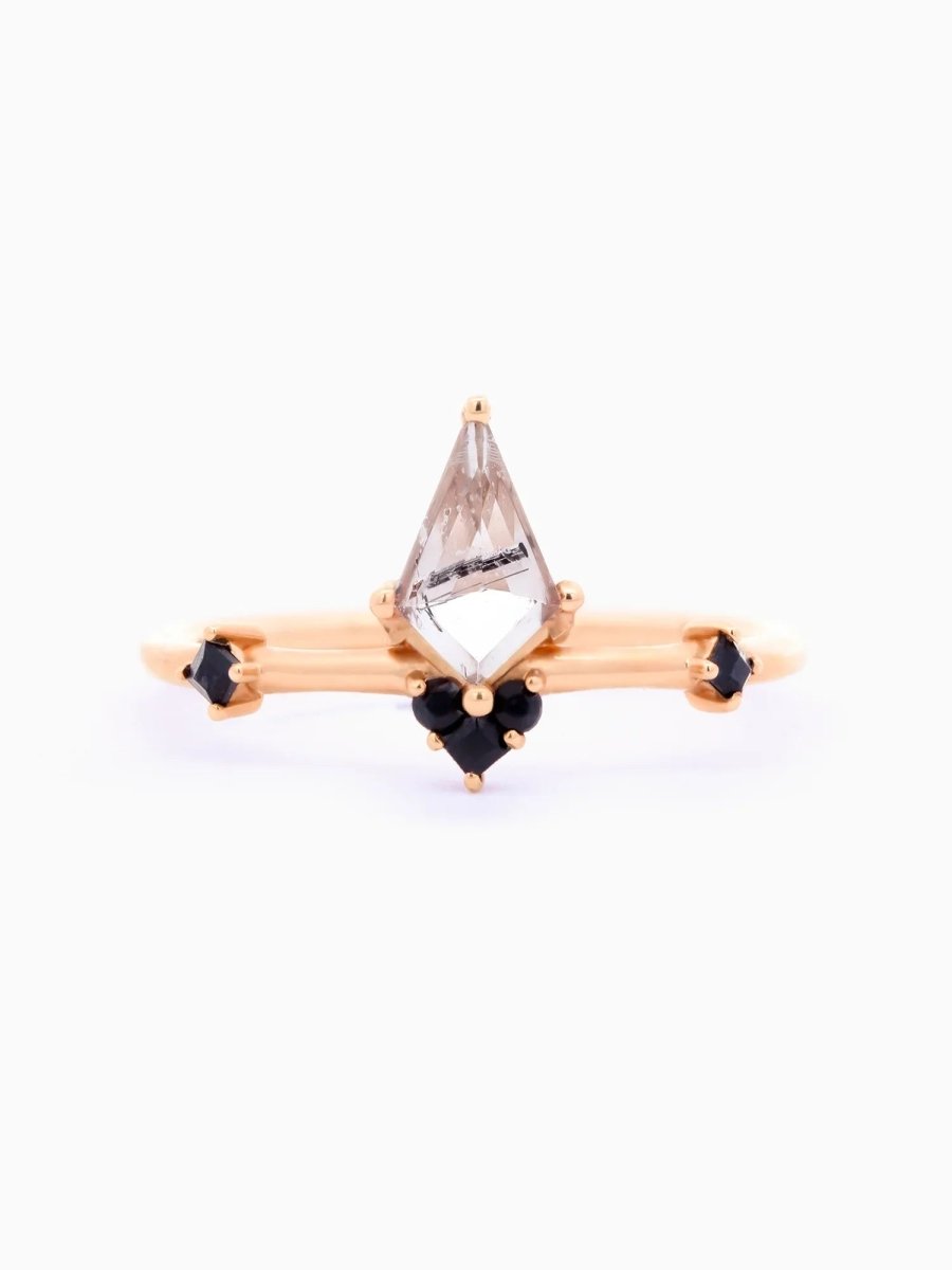 Face view of minimalist Art Deco ring with kite tourmalinated center, trefoil onyx cluster, square onyx sides, tapered band